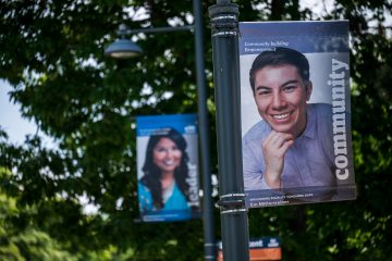 Two campus pole banners each depicting a different person smiling